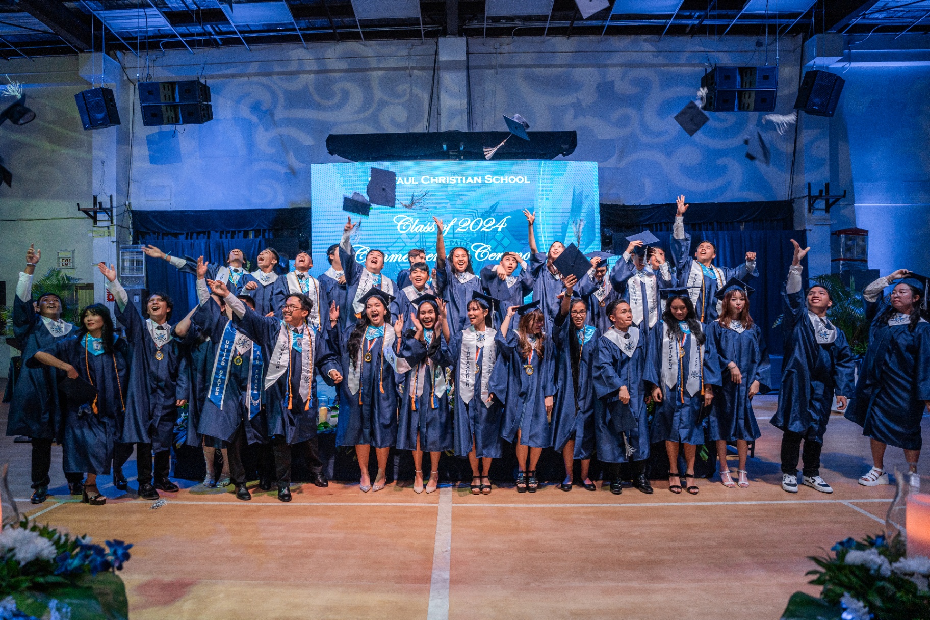 Saint Paul Christian School graduates throwing their caps